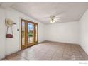 Bright living room featuring a ceiling fan, neutral walls, and tiled floors at 529 Main St, Louisville, CO 80027