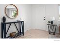 A bright entry featuring light flooring, decorative console table with decor, and a round mirror at 5329 Flower Cir, Arvada, CO 80002
