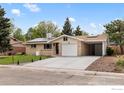 Attractive front home exterior with a well manicured lawn and a long driveway at 5329 Flower Cir, Arvada, CO 80002