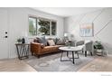 Stylish living room featuring a large window, a comfy sofa, and a modern geometric wall design at 5329 Flower Cir, Arvada, CO 80002