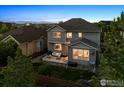 A two-story home with a fenced backyard and a cozy patio that includes outdoor furniture and professional landscaping at 610 Sun Up Pl, Erie, CO 80516