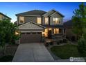 Charming two-story home with manicured lawn, stone accents, a covered porch and a two car garage at 610 Sun Up Pl, Erie, CO 80516