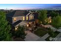 Aerial view of a two-story home with great curb appeal including professional landscaping and mountain views at 610 Sun Up Pl, Erie, CO 80516