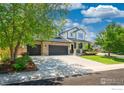 Inviting two-story home boasts stone accents, three-car garage, large driveway and lush landscaping at 6488 Tilbury Ave, Firestone, CO 80504