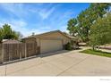 Detached two-car garage with a wide driveway and partial privacy fence nestled on a sunny lot at 9598 Lowell Blvd, Westminster, CO 80031