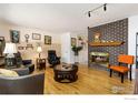 Bright living room boasts a brick fireplace, hardwood floors, and stylish decor at 9598 Lowell Blvd, Westminster, CO 80031
