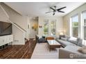 Bright living room with hardwood floors, a ceiling fan, and large windows providing ample natural light at 11033 E 28Th Pl, Denver, CO 80238