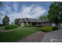 Well-maintained single-story home with lush landscaping and a well manicured lawn at 1314 State Highway 66 Hwy, Longmont, CO 80504