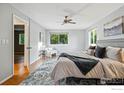Bright main bedroom boasting hardwood floors, ample natural light, a ceiling fan, and a stylish area rug at 1359 Caledonia Cir, Louisville, CO 80027