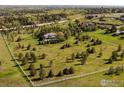 Expansive aerial view of a beautiful property with sprawling green lawns, mature trees, and a custom home at 160 Ponderosa Dr, Boulder, CO 80303