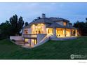 Stunning rear exterior featuring a covered deck, expansive patio and walkout basement on a landscaped lot at 160 Ponderosa Dr, Boulder, CO 80303