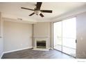 Inviting living room with cozy fireplace, ceiling fan, and sliding door to the outside at 1652 Egret Way, Superior, CO 80027