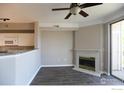 Inviting living room with cozy fireplace, ceiling fan, and sliding door to the outside at 1652 Egret Way, Superior, CO 80027