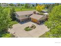 Aerial view of a charming two-story home with a spacious yard and mature trees at 1921 Glenview Ct, Berthoud, CO 80513