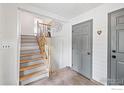Bright entryway with wooden stairs, neutral walls, and tile floors at 1921 Glenview Ct, Berthoud, CO 80513