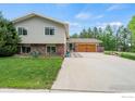 Charming two-story home with brick accents, a large driveway, and a well-maintained front yard at 1921 Glenview Ct, Berthoud, CO 80513