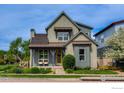 Charming two-story home featuring a well-manicured lawn and inviting front porch with seating at 2369 Hecla Dr, Louisville, CO 80027