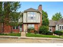 Charming red brick townhome exterior with a well-manicured lawn and inviting entrance at 3022 W 107Th Pl # D, Westminster, CO 80031
