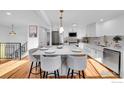 Bright kitchen featuring an island with seating, modern appliances, and stylish white cabinetry and countertops at 4642 Everett Ct, Wheat Ridge, CO 80033
