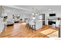 Spacious living area with hardwood floors, a kitchen island with stools, and a comfortable seating area at 4642 Everett Ct, Wheat Ridge, CO 80033