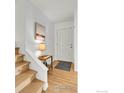 Bright entryway featuring hardwood floors, a staircase, and modern decor at 4658 Ingram Ct, Boulder, CO 80305