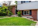 Home exterior featuring a brick facade and manicured lawn with beautiful landscaping at 4658 Ingram Ct, Boulder, CO 80305