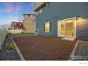 A mulch-covered backyard featuring a stone border and access to sliding glass door at 542 Highlands Cir, Erie, CO 80516