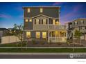 Two-story home features a covered porch with white railing and neatly kept front yard at 542 Highlands Cir, Erie, CO 80516