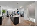 Open-concept kitchen with a large island and views of the fireplace and living area at 542 Highlands Cir, Erie, CO 80516