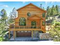 Charming mountain home with wood siding, large windows, an attached garage, and stone accents at 84 Canon View Rd, Boulder, CO 80302