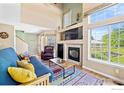 Bright living room with a fireplace, large windows, and vaulted ceilings at 930 Button Rock Dr # 28, Longmont, CO 80504
