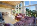 Bright living room featuring high ceilings, large windows, wood floors, comfortable seating and fireplace at 100 Wildcat Ln, Boulder, CO 80304