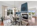 Bright dining room with a fireplace, large window and views of the green landscape at 102 Ortega Ct, Erie, CO 80516