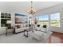 Living room features an open design, plush seating, and large windows with views at 102 Ortega Ct, Erie, CO 80516
