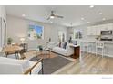 Bright living room with wood floors, neutral decor, comfortable seating and a modern ceiling fan at 113 Marlowe Dr, Erie, CO 80516
