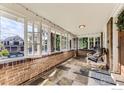 Relaxing sunroom with brick half wall, tiled floors, and windows offering a view of the outdoors at 1230 S Emerson St, Denver, CO 80210