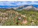 Aerial view of a home nestled in trees with majestic mountain views at 133 Mine Ln, Boulder, CO 80302