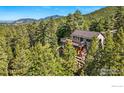 A picturesque view of a home surrounded by lush greenery, featuring a deck and natural landscaping at 141 Millionaire W Dr, Boulder, CO 80302