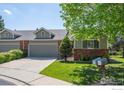 Charming home with a two-car garage, brick accents, and a well-maintained front yard and blue sky at 1528 16Th Pl, Longmont, CO 80501
