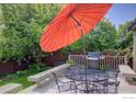 Inviting outdoor deck area with an umbrella, grill, and seating, ideal for entertaining and enjoying the outdoors at 1574 Goshawk Dr, Longmont, CO 80504