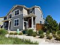 Charming gray two-story home with a cozy front porch and well-maintained landscaping at 17616 Bluetrail Ave, Parker, CO 80134
