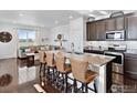 Open-concept kitchen with island, seamless flow into the living area, and modern finishes at 17616 Bluetrail Ave, Parker, CO 80134