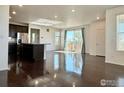 Bright open-concept living room featuring hardwood floors, large windows, and a modern kitchen island at 17616 Bluetrail Ave, Parker, CO 80134