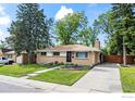 Well-maintained ranch-style home with a manicured lawn, mature trees, and inviting curb appeal at 1880 E 84Th Ave, Denver, CO 80229