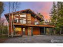 Stunning log home with large deck, stone accents, and garage, set against a vibrant sky at 216 N Gold Flake, Breckenridge, CO 80424