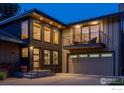 Charming two-story home features a modern design with a balcony and garage in the evening at 2575 Briarwood Dr, Boulder, CO 80305