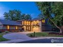 Charming two-story home features a modern design with a balcony and garage in the evening at 2575 Briarwood Dr, Boulder, CO 80305