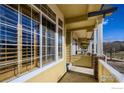 Exterior view of a covered porch with brick pillars and large windows, showcasing the home's facade at 2855 Rock Creek Cir # 200, Superior, CO 80027