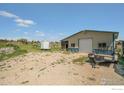 Outbuilding with a large roll-up door, and trailer at 3412 Erving Ct, Berthoud, CO 80513