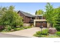 Stunning two-story home boasting a stone and wood facade, complemented by a well-manicured front yard and a spacious driveway at 3737 Spring Valley Rd, Boulder, CO 80304